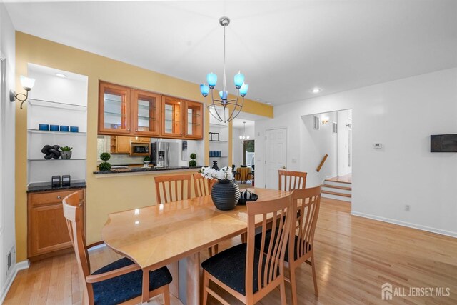 dining area with light wood-style floors, recessed lighting, baseboards, and a notable chandelier