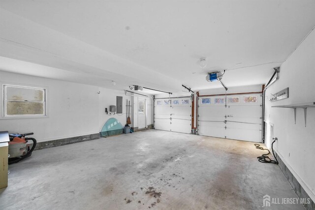 garage with a garage door opener and electric panel