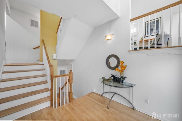 stairs featuring wood finished floors and visible vents