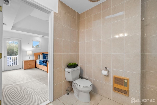 bathroom featuring tile walls, heating unit, visible vents, toilet, and tile patterned floors