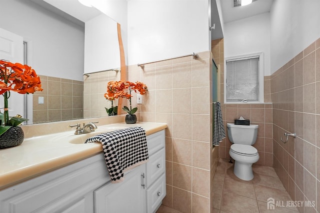 full bath with toilet, tile patterned floors, vanity, and tile walls