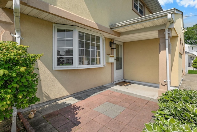 53 Tennyson St, Carteret, NJ 07008 - view of exterior entry with stucco siding and a patio area