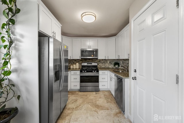53 Tennyson St, Carteret, NJ 07008 - kitchen with appliances with stainless steel finishes, light stone finish floors, white cabinetry, dark stone countertops, and decorative backsplash