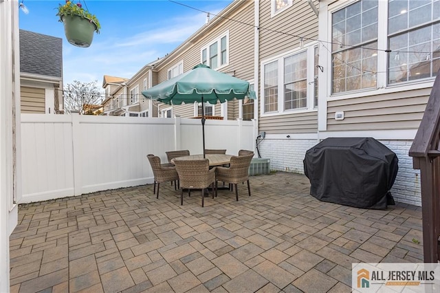 view of patio with outdoor dining space, a fenced backyard, and area for grilling
