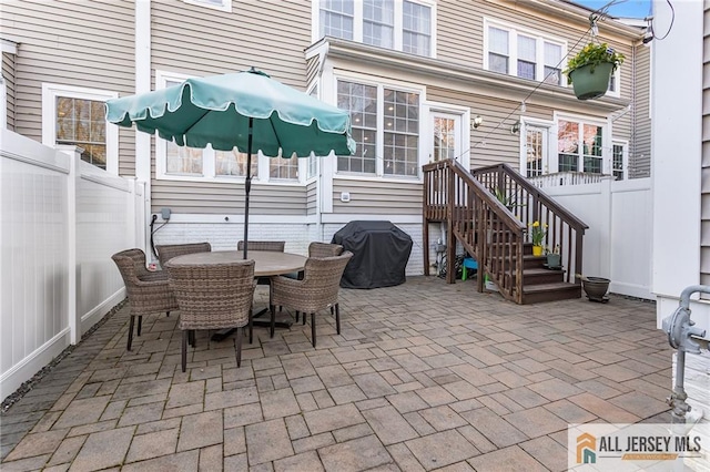 view of patio featuring grilling area, outdoor dining area, and a fenced backyard