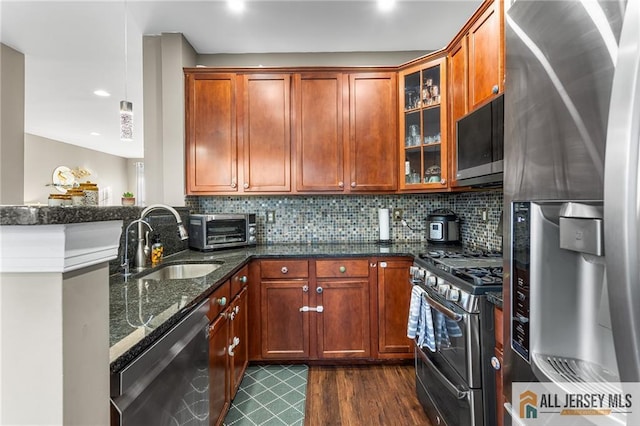kitchen featuring a sink, tasteful backsplash, a toaster, and stainless steel appliances