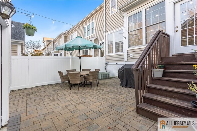 view of patio / terrace with grilling area, outdoor dining space, and fence