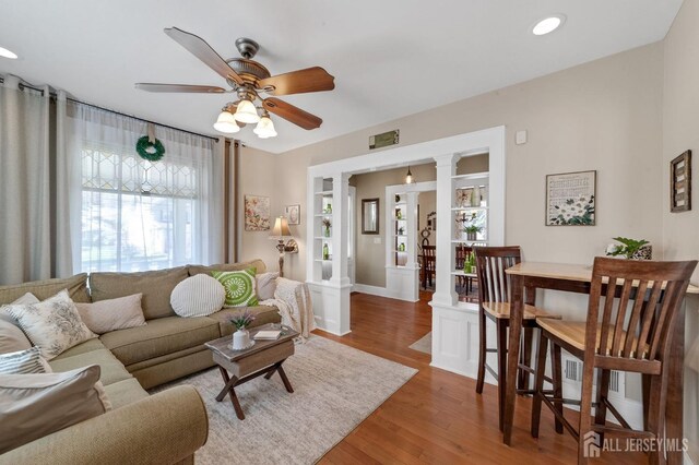living area featuring recessed lighting, a ceiling fan, wood finished floors, and baseboards