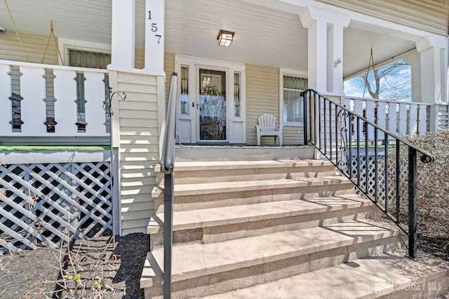view of exterior entry featuring covered porch