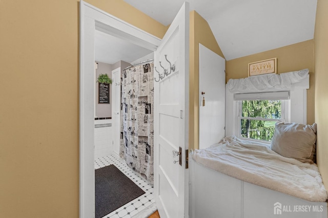 full bath featuring curtained shower and lofted ceiling