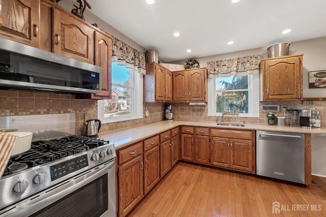 kitchen featuring a healthy amount of sunlight, appliances with stainless steel finishes, light countertops, and a sink