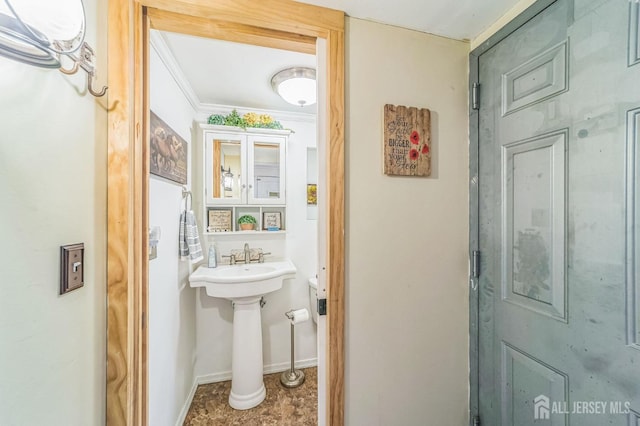 bathroom with ornamental molding and baseboards