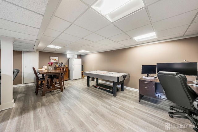 home office with a paneled ceiling, wood finished floors, and baseboards
