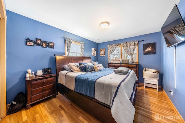 bedroom with baseboards and wood finished floors