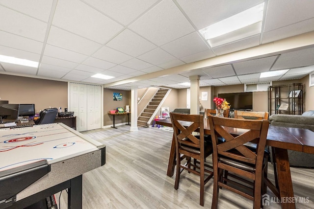 playroom featuring light wood-style flooring and a drop ceiling