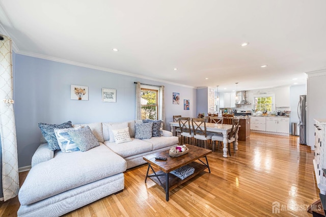 living area featuring recessed lighting, light wood-type flooring, and crown molding