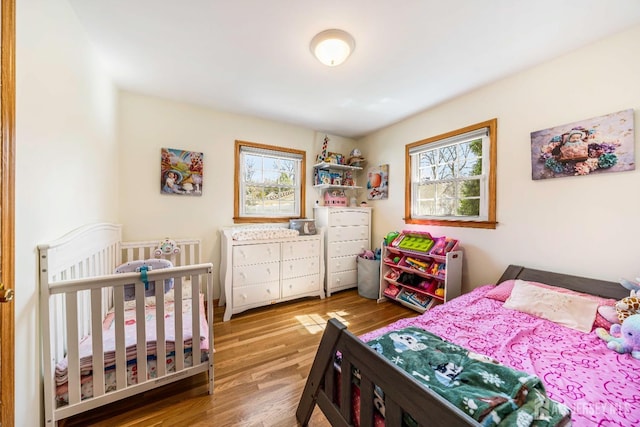 bedroom featuring wood finished floors and multiple windows