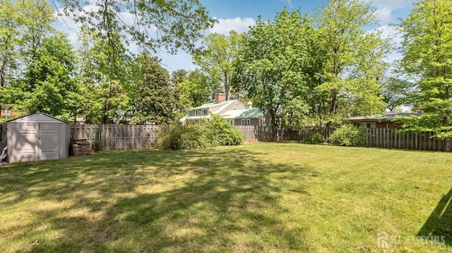 view of yard with a storage shed, an outdoor structure, and a fenced backyard