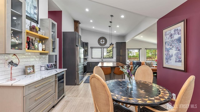 dining room with wine cooler, lofted ceiling, light wood finished floors, and recessed lighting