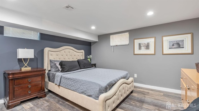 bedroom featuring wood finished floors, visible vents, baseboards, and recessed lighting