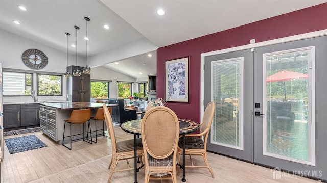 dining space with light wood finished floors, lofted ceiling, french doors, and recessed lighting