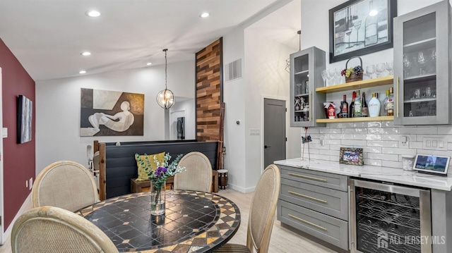 bar with beverage cooler, visible vents, a dry bar, vaulted ceiling, and recessed lighting
