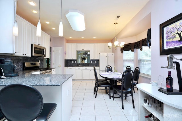 137 Murano Ave, Monroe, NJ 08831 - kitchen with stainless steel appliances, decorative backsplash, light tile patterned flooring, a chandelier, and white cabinetry