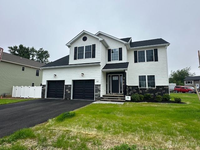 view of front facade featuring stone siding, driveway, and a garage