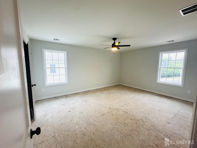 unfurnished room with a ceiling fan and baseboards