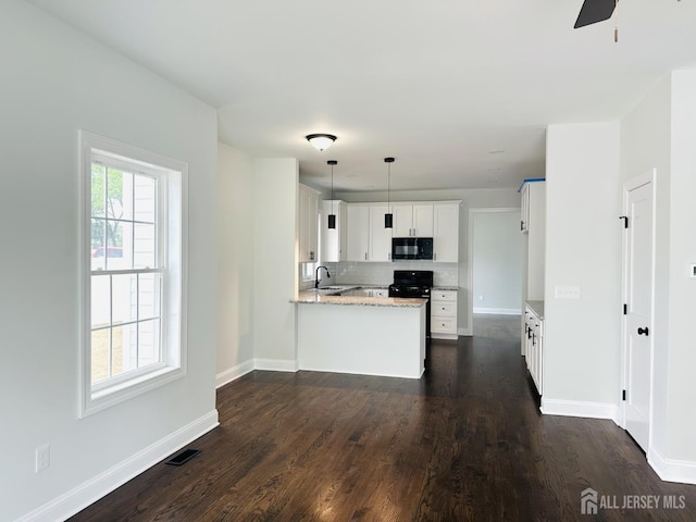 kitchen featuring black appliances, a peninsula, baseboards, and dark wood finished floors