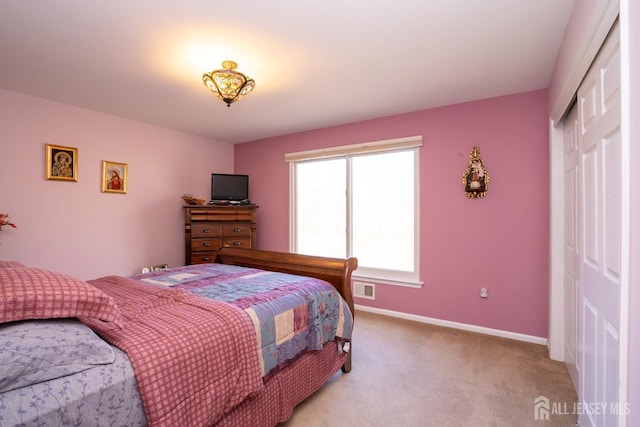 bedroom with a closet, visible vents, light colored carpet, and baseboards