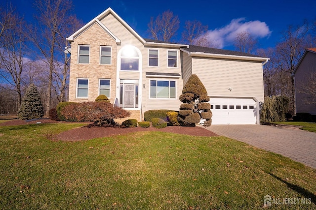 traditional-style home featuring decorative driveway, a garage, and a front yard