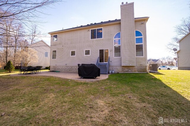 rear view of property with central AC, a patio, and a lawn