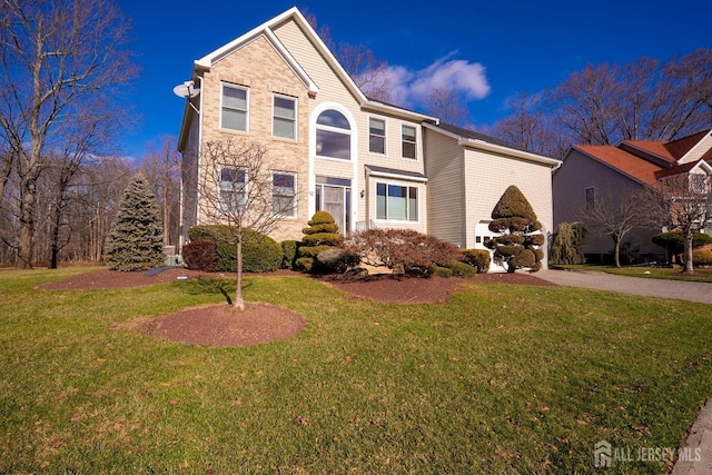 traditional home with brick siding and a front yard