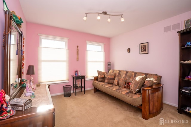 living room with visible vents, light carpet, and baseboards