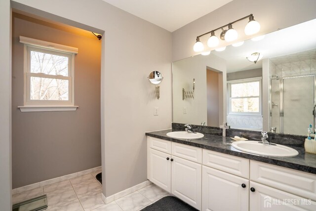 bathroom featuring vanity, a shower with door, and tile patterned flooring