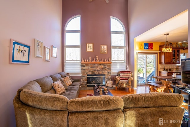 living room with a fireplace and a high ceiling