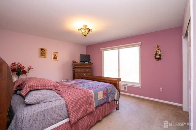 bedroom with light carpet, visible vents, and baseboards