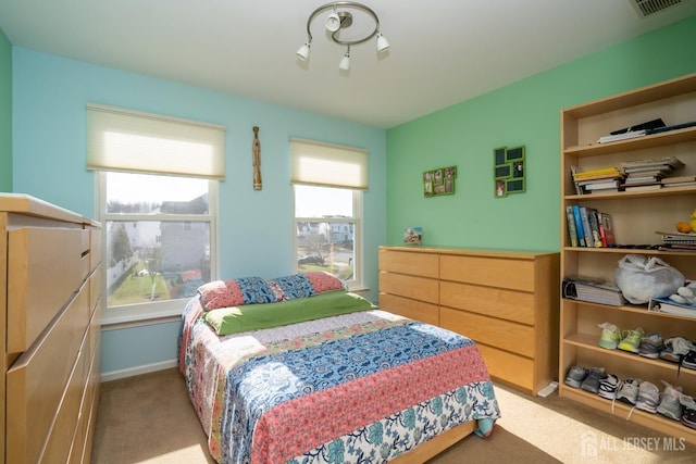 bedroom featuring baseboards, light carpet, and visible vents