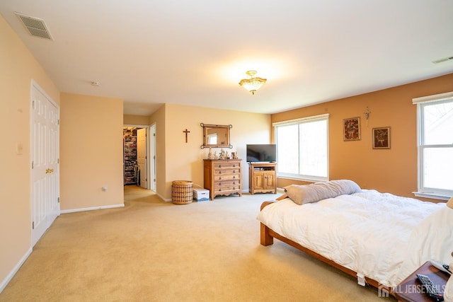 bedroom with baseboards, visible vents, and light carpet