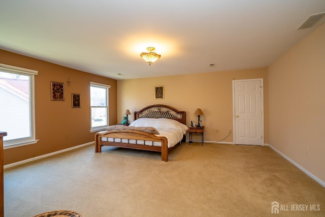 bedroom featuring visible vents, light carpet, and baseboards