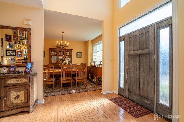 foyer entrance with an inviting chandelier and light hardwood / wood-style flooring