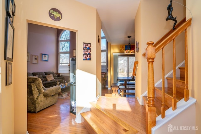 entryway with a wealth of natural light, stairway, and wood-type flooring