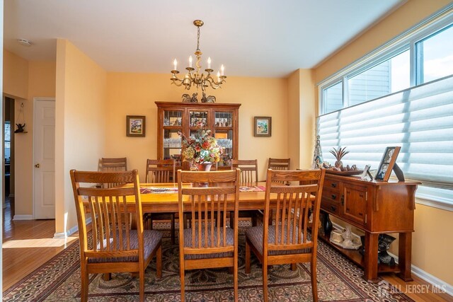 dining area featuring wood-type flooring and a notable chandelier