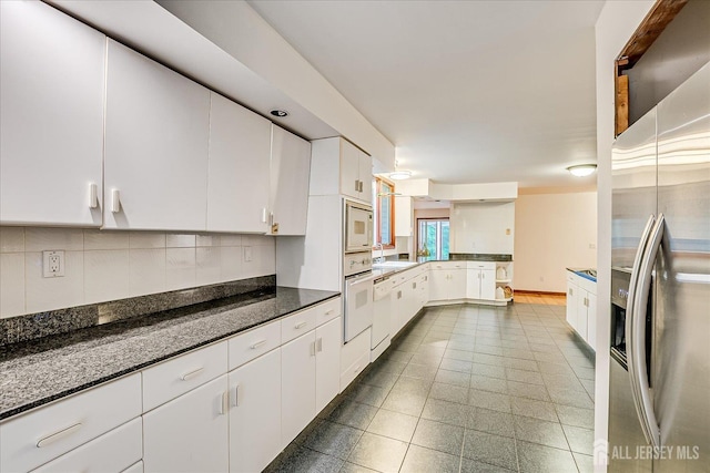 16 Benedek Rd, Princeton, NJ 08540 - kitchen with white appliances, backsplash, white cabinets, a peninsula, and dark stone countertops