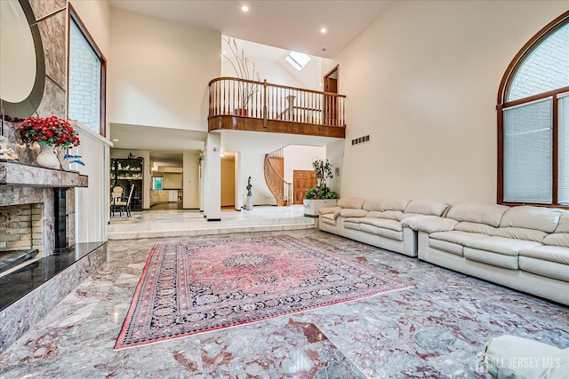 16 Benedek Rd, Princeton, NJ 08540 - living area featuring high vaulted ceiling, marble tiled flooring, a fireplace with raised hearth, a skylight, and recessed lighting
