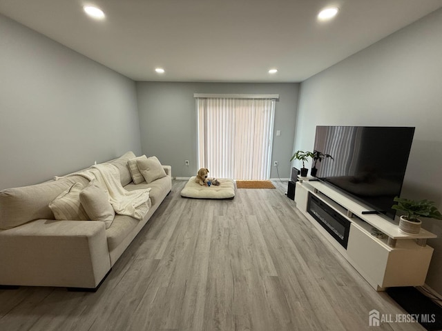 living room with baseboards, wood finished floors, and recessed lighting