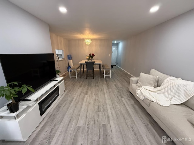 living room featuring recessed lighting, light wood-type flooring, and baseboards