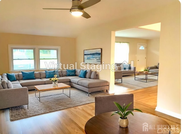 living room featuring hardwood / wood-style floors, ceiling fan, and lofted ceiling