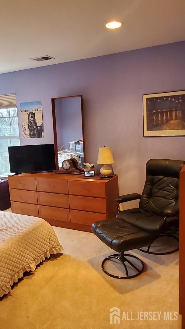 carpeted bedroom with visible vents and recessed lighting